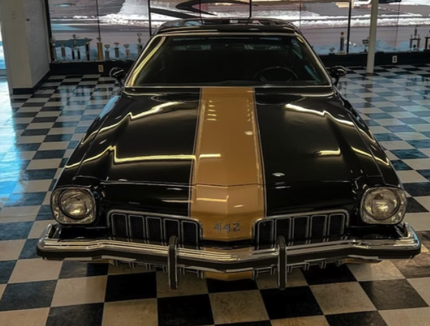 Classic black and gold Oldsmobile detailed in the shop